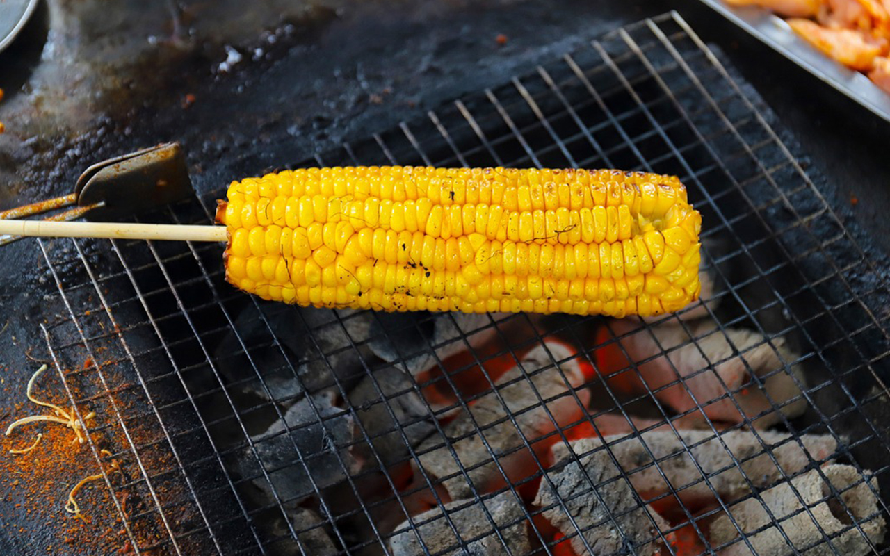 En grillad majskolv på en grill med majskol.